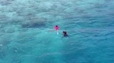 Güneş doğduktan sonra beyaz kumlu arka planda berrak bir göl kenarında egzotik sahil tatili manzarası.