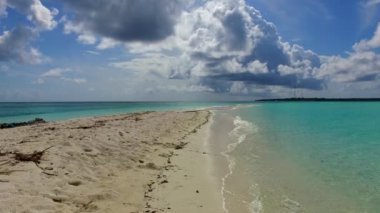 Kusursuz sahil macerasının gündüz yolculuğu sığ bir göl ve dalgaların yakınındaki beyaz kum arka planı.