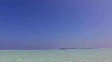 Lüks lagün sahil seyahatinin geniş açılı manzarası, tatil köyünün yakınındaki parlak kumlu arka planda berrak bir göl.