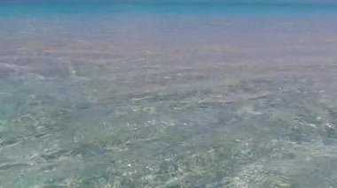 Güneş doğduktan sonra beyaz kumlu arka planlı, mavi okyanus kıyısında tropik tatil beldelerinin gündüz yolculuğu.