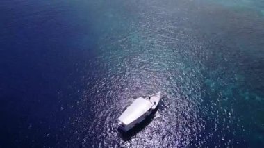 Lüks sahil sahillerinin romantik deniz manzarası mavi deniz kıyısında ve tatil köyü yakınlarında beyaz kumlu arka planda.