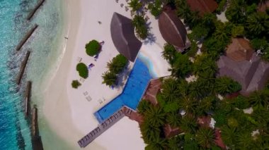 Sakin sahil sahili macerasının güneşli doğası. Resifin yanında temiz kum arka planına sahip berrak su.