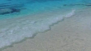 Sakin sahil sahillerinin hava aracı gökyüzü mavi deniz ve beyaz kumlu zemin tarafından kırılıyor