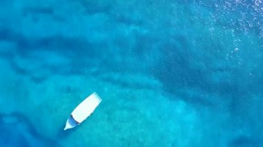 Mavi okyanus kıyısındaki güzel sahil gezisinin geniş açılı manzarası. Parlak kum arka planı güneş ışığı altında.