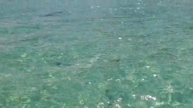 Gün batımından önce beyaz kumlu arka planda mavi yeşil suların rahatlatıcı turist plaj macerasının romantik dokusu