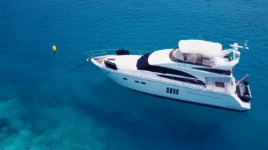 Gün batımından önce beyaz kumlu arka plan ile mavi deniz kenarındaki sakin deniz manzarasını kapatın.