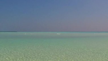 Sahil kenarındaki beyaz kumlu arka planda, berrak deniz kıyısında lüks turist macerasının ılık dokusu