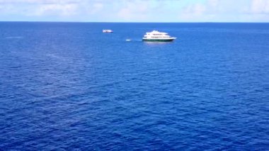 Lüks lagünün sığ okyanus ve palmiyelerin yakınındaki beyaz kum arka planındaki lüks göl macerasının soyutlamasını kopyala