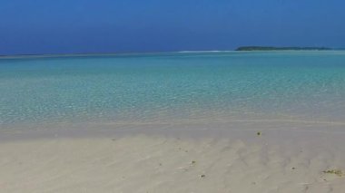 Geniş açılı cennet sahili deniz yolculuğu sığ sularda ve dalgaların yanında beyaz kum arka planında.