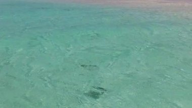 Göksel turist plaj tatilinin mavi su ve beyaz kum arka planında güneş doğduktan sonra geniş açılı yolculuğu