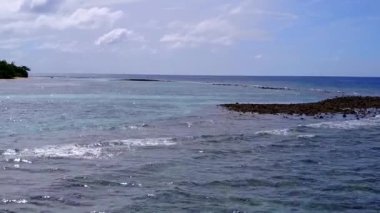 Mavi lagün ve dalgaların yakınındaki beyaz kumlu arka planda mükemmel sahil gezisi manzarası