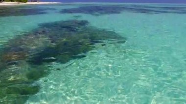 Mavi okyanus kıyısındaki deniz kıyısı gezisi ve tatil köyü yakınlarındaki beyaz kumların soyutlanması.