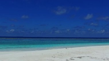 Deniz kenarındaki sakin sahil yaşam tarzının yaz manzarası ve kumsal kenarındaki beyaz kum arka planı.