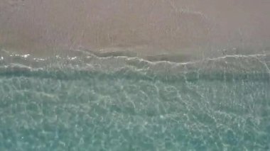 Turkuaz okyanus ve kumsalın yakınındaki beyaz kum arka planıyla lüks turistik plaj tatilinin deniz manzarasını kapatın.