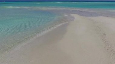 Lüks sahil sahil tatilinin geniş açılı doğası şeffaf okyanus ve dalgaların yanında beyaz kumlu arka plan.