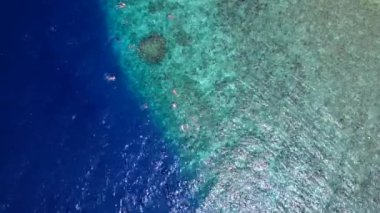 Sörf yapmaya yakın beyaz kumlu arka planlı sığ okyanus kıyısındaki sakin körfez plaj gezisi.