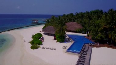 Deniz manzaralı sıcacık bir manzara. Deniz mavisi okyanus kenarında, güneş ışığında beyaz kum arka planında.