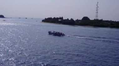 Açık okyanus kıyısındaki deniz turistleri ve sörfün yakınındaki temiz kum arka planının sıcak soyutlanması.
