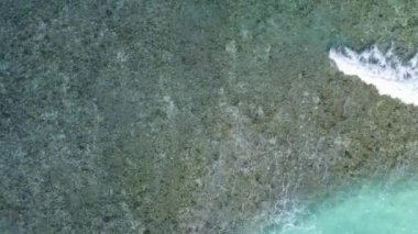 Sahil kenarındaki beyaz kum arka planlı mavi okyanus kıyısındaki gevşetici turist plajı deniz manzarasını kopyala