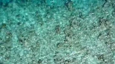 Turkuaz deniz kıyısındaki mükemmel adanın geniş açılı doğası ve tatil beldesi yakınında beyaz kum arka planı.