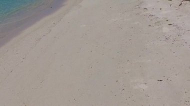 Mavi deniz kıyısında egzotik göl gezisinin gündüz panoraması ve dalgaların yanında beyaz kumlu arka plan