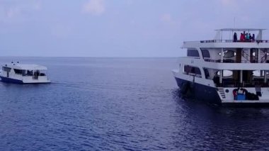 Mavi lagünün yanında, dalgaların yanında beyaz kumlu arka planda dinlenme sahili zamanının sıcak soyutlaması.