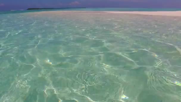 サンゴ礁の近くに白い砂浜の背景を持つ青い海による完璧な海の景色のビーチタイムの宇宙観光をコピー — ストック動画