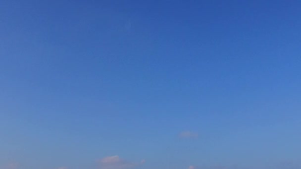Солнечная панорама роскошного пляжного отдыха с видом на море на фоне низкого моря и белого песка у волн — стоковое видео