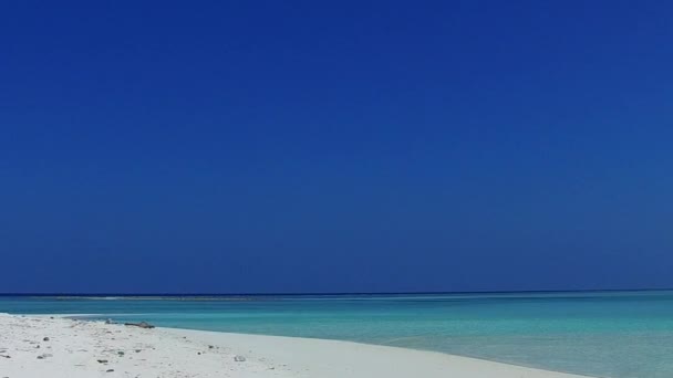 Słoneczna faktura morskiego wybrzeża plaża dzika przyroda przez niebieski ocean z jasnym tle piasku po wschodzie słońca — Wideo stockowe