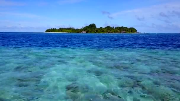 Güzel ada plajının geniş açılı manzarası mavi okyanusu aşıyor ve beyaz kum arka planda güneş ışığı var. — Stok video