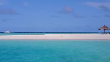 Sahil yolculuğunun romantik doğası berrak su ve resifin yakınındaki parlak kum arka planı.