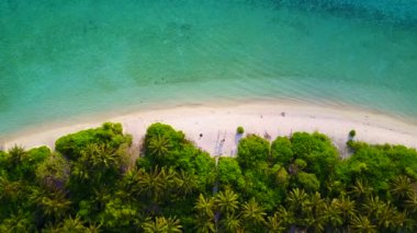Sakin bir tatil köyünün sahil saatine yakın temiz okyanus ve dalgaların yakınındaki beyaz kum arka planı.