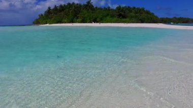 Avuç içleri beyaz kumlu arka planda, su mavisi deniz kıyısında lüks deniz kıyısı yaşam tarzının güneşli soyut bir örneği.