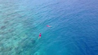 Deniz manzaralı sahil yolculuğunun geniş açılı dokusu mavi lagünün yanında tatil köyü yakınlarında beyaz kumlu arka planda.