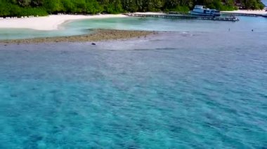 Açık okyanus kıyısındaki güzel sahil turizminin geniş açılı turizmi. Beyaz kumlu arka plan güneş ışığı altında.