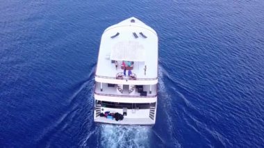 Mavi deniz kıyısında gündüz deniz manzarası ve güneş ışığında beyaz kumlu arka plan