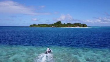 Mavi yeşil lagün ve kumsalın yakınındaki beyaz kum arka planındaki boş gökyüzü.
