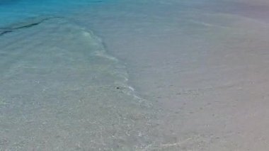Turkuaz denizinin güneş ışığında parlak kum arka planına sahip egzotik sahil macerasının güneşli doğası