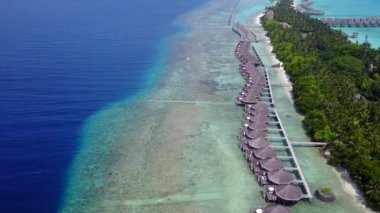 Mavi göl kıyısındaki tropikal sahil gezisinin deniz manzarasını kapatın ve dalgaların yakınındaki parlak kumlu arka plan