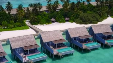 Deniz lagününün güneşli turizmi şeffaf deniz ve beyaz kum arkaplanından güneş ışığıyla ayrılıyor.