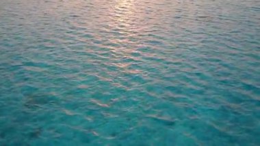 Mavi lagün ve dalgaların yakınındaki beyaz kum arka planının rahatlatıcı sahil maceralarının ılık deniz manzarası