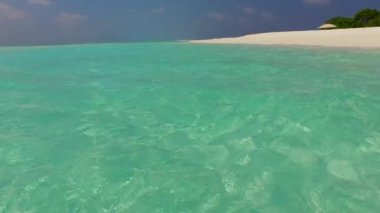 Deniz kıyısı sahil yaşam tarzının ılık turizmi. Açık okyanus, dalgaların yanında beyaz kumlu arka plan.