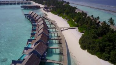 Mavi okyanus ve beyaz kumlu arka plan ile lüks ada sahil yolculuğunun insansız hava aracı doğası