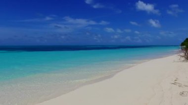 Mavi okyanus kıyısındaki sakin sahil tatilinin ve dalgaların yakınındaki beyaz kumlu arka planın uzay yolculuğunu kopyala