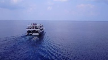 Egzotik ada plajının ılık turizmi açık lagün ve kumsalın yakınındaki parlak kum arka planını yarıp geçiyor.