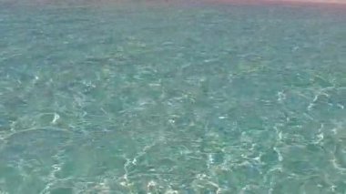 Deniz kıyısının güneşli gökyüzü. Turkuaz deniz kıyısında. Resif yakınlarında temiz kumlu bir zemin var.