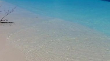 Cennet tatil beldesi sahil macerasının geniş açılı yolculuğu. Mavi okyanus, dalgaların yanında beyaz kumlu arka plan.