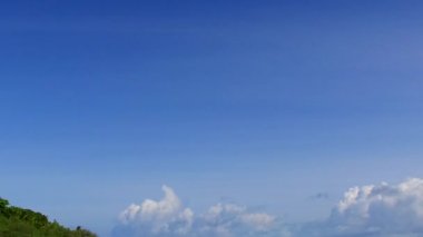 Güneş doğduktan sonra beyaz kum arka planıyla mavi okyanus kıyısında mükemmel sahil plajı olan gündüz gökyüzü.