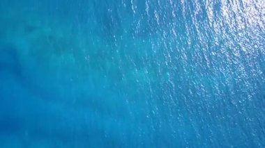 Deniz adası sahil macerasının doğasını sığ sularda, temiz kumlu arka planda, sörfün yanında kapatın.