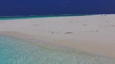 Güzel sahil tatilinin boş yolculuğu sığ sularda, tatil köyünün yakınındaki parlak kumlu arka planda.